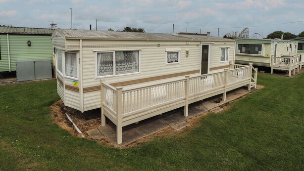 A row of mobile homes with a fenced deck area. - Caravan 25 (Skegness)
