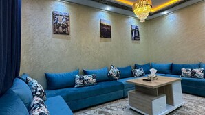 A modern living room with a sectional sofa, a coffee table, and decorative wall art.