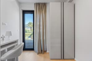 A modern room with a sliding door to a balcony, a white desk with a lamp, and a grey chair. - Beautiful 3-bedroom apartment with AC in charming Kaštel Stari (Kaštel Stari)