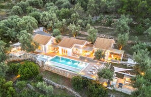 A villa with a swimming pool, multiple outdoor seating areas, and a stone pathway. - Villa Galini - Charming Villa with Sea Views & Large Private Pool near Beach (Lefkada)