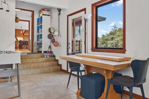 A modern kitchen with a wooden table, chairs, and a window with a view of trees. - Sebastopol 4BR hilltop home with hot tub, wood stove & game room, dogs welcome (Sebastopol)