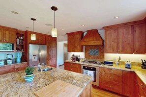 A kitchen with wooden cabinets, granite countertops, a stainless steel refrigerator, a stove, and a sink. - Dog-Friendly Sebastopol Pool Home & Spa with Hot Tub (Sebastopol)