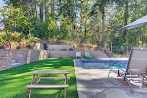 A backyard with a swimming pool, a picnic table, and lounge chairs. - Sebastopol 4BR hilltop home with hot tub, wood stove & game room, dogs welcome (Sebastopol)