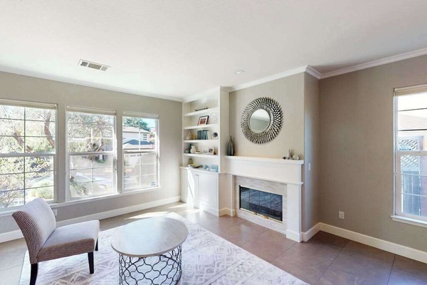 Cozy up by your gas fireplace in this elegant sitting room with built-in bookshelves and picture windows — perfect for a quiet Sonoma evening in.