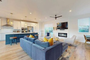 A modern kitchen with white cabinets, a central island, and pendant lighting.