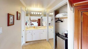 Une salle de bain d’hôtel dotée d’un grand miroir, d’un meuble-lavabo et d’un dressing avec un miroir.