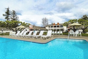 A swimming pool with lounge chairs and umbrellas, surrounded by buildings and trees. - Napa Silverado studio with golf & Atlas Peak views, pool access (Napa)