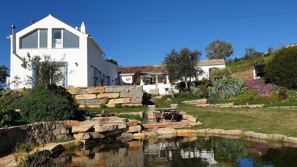 A white house with a stone wall, a pond, and a patio with chairs. - Peaceful Beautiful Countryside Perfect Destination (Tavira)