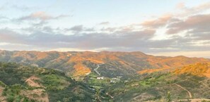 Un paisaje montañoso con una carretera sinuosa y edificios dispersos.