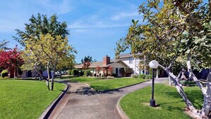 A residential street with houses, a curved driveway, and a street lamp. - Napa 2BR Silverado condos — two kings, full kitchen, golf views (Napa)