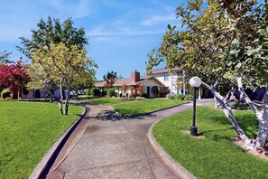 A residential street with houses, a curved driveway, and a street lamp. - Napa 2BR Silverado condo — two king suites, golf views & pool (Napa)