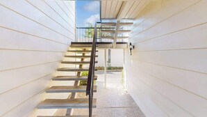 A staircase with a metal handrail leading to a covered outdoor area. - Napa 2BR Silverado condos — two kings, full kitchen, golf views (Napa)