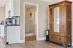 A modern kitchen with a built-in microwave, a coffee machine, and a refrigerator. - Bodega Bay waterfront studio cottage on stilts — 1 bed, gas fireplace (Bodega Bay)