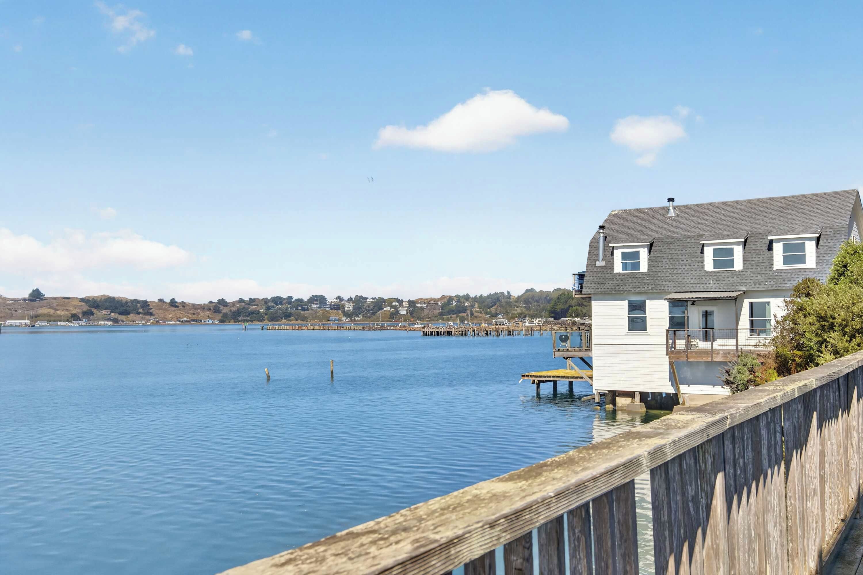 Ein Anwesen am Wasserufer mit einer Holzterrasse und einem Haus direkt am See.
