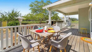A wooden deck with a table and chairs, a covered area, and a white railing. - Healdsburg 3BR vineyard farmhouse with game barn & wood fireplace (Healdsburg)