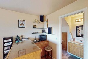 A compact kitchen with a wooden countertop, a sink, and a small stool. There is a shelf with various items and a speaker mounted on the wall. - Cloverdale 3BR hillside lodge on 7 acres with hot tub & wave pool (Cloverdale)