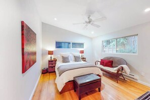 A bedroom with a bed, bedside tables, a chair, a ceiling fan, and a window. - Guerneville Dog-Friendly Redwood Retreat with Hot Tub & Pool (Guerneville)