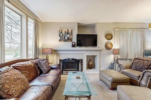 A living room with a fireplace, leather sofas, a glass coffee table, and a television. - Dog-Friendly Santa Rosa Home near Wineries (Santa Rosa)