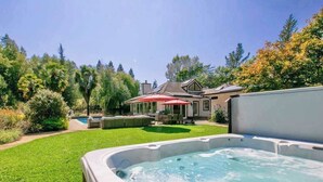 A backyard with a hot tub, a pool, and a patio area with umbrellas. - Sonoma 4BR wine country estate on 6 acres — pool, hot tub, sleeps 14 (Sebastopol)