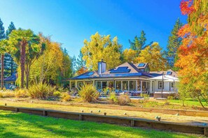 A house with a covered porch, a solar panel, and a garden with various plants. - Zegarra Estate -- 6-acre Sonoma wine country compound, sleeps 14 across two homes (Sebastopol)