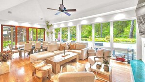 A spacious living room with a large sofa set, a coffee table, and a dining area with chairs and a table. - Sonoma 4BR wine country estate on 6 acres — pool, hot tub, sleeps 14 (Sebastopol)