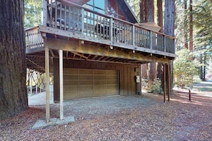 A two-story building with a balcony, a garage, and a tree in the background. - Redwood Lodge - A-Frame on the Russian River (Monte Rio)