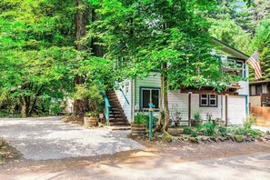 A house with a porch, a staircase, and a flag. - Guerneville Dog-Friendly Redwood Retreat with Deck (Guerneville)