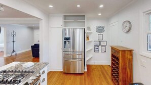 Una cocina moderna con un refrigerador de acero inoxidable, un horno empotrado y una estantería para vinos.