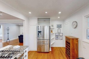 A modern kitchen with a stainless steel refrigerator, a built-in oven, and a wine rack. - Santa Rosa 2BR home with shaded patio — walk to Willi's Wine Bar (Santa Rosa)