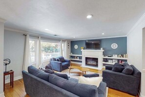 A living room with a fireplace, two sofas, a coffee table, and a TV. - Santa Rosa 2BR home with shaded patio — walk to Willi's Wine Bar (Santa Rosa)