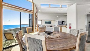 A dining area with a round table, chairs, and a view of the ocean. - Bodega Bay 5BR ocean-view home with hot tub — dogs welcome (Bodega Bay)