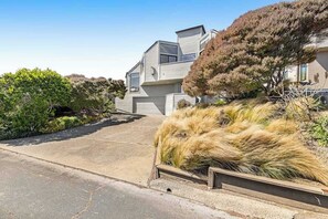 Ein modernes, zweistöckiges Haus mit gepflasterter Auffahrt und einem angelegten Garten.