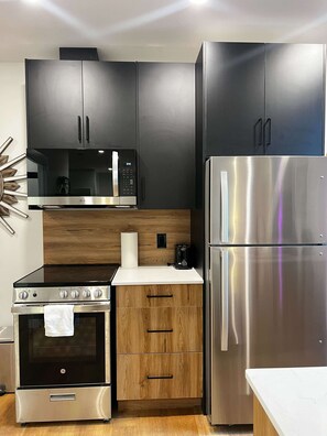 Eine moderne Küche mit Mikrowelle, Herd, Backofen und Kühlschrank.