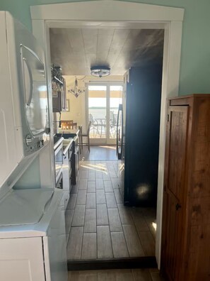 Cozinha com vista para o exterior, armário de madeira e ventilador de teto.