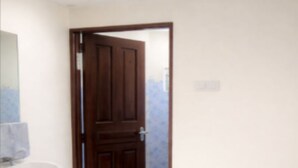 A bathroom with a wooden door, a white sink, and a patterned floor. - Mombasa:4 bedroom house :International chef ,tour guide.Perfect for family party (Mombasa)