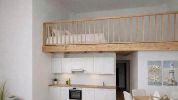 Eine kleine Küche mit weißen Schränken, einer Holz Arbeitsplatte und einem eingebauten Ofen.