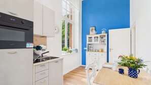 Una cocina moderna con horno empotrado, un lavaplatos y un comedor con mesa y sillas.