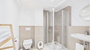 Une salle de bain moderne avec une douche à parois de verre, des toilettes et un lavabo.