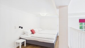 Une chambre à coucher avec un lit, une table de chevet et un luminaire suspendu.