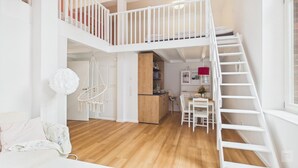 Un intérieur à plusieurs niveaux comprenant un escalier, un coin cuisine et un espace repas.