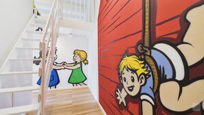 Una escalera con barandilla y una pared con un personaje de caricatura.