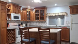 Una cocina con armarios de madera, un microondas, una estufa y un ventilador de techo.