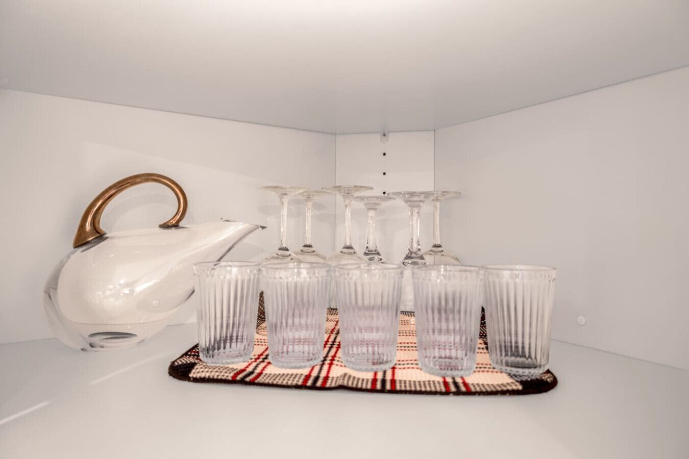 Une bouilloire blanche et six verres transparents sur un plateau.