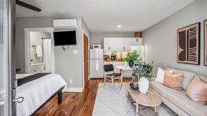 Eine moderne Wohnung mit Schlafzimmer, Küchenzeile und Wohnbereich.