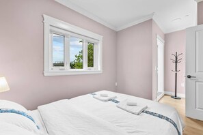 A bedroom with a bed, a window with a view, and a coat rack. - Modern Private 3BR House Vancouver (Vancouver)