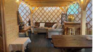 Accogliente interno di una baita con pareti in legno, un divano, un tavolo da pranzo e una panca.