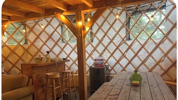 Un interno rustico in legno con un tavolo, degli sgabelli e un divano.