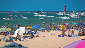 A beach with boats and people. - Experience Coast Guard Festival Like a Local in a Charming Downtown Cottage (Grand Haven)