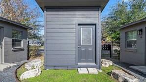 Un petit bâtiment d’un seul étage, à l’extérieur gris, avec une porte d’entrée et une fenêtre.
