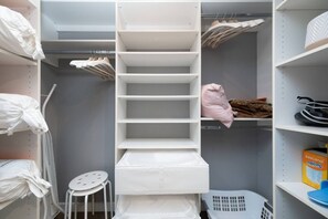 A storage closet with shelves, a hanging rack, and a laundry basket. - Brand New Stylish 2-Bedrooms Suite in Shaughnessy (Vancouver)